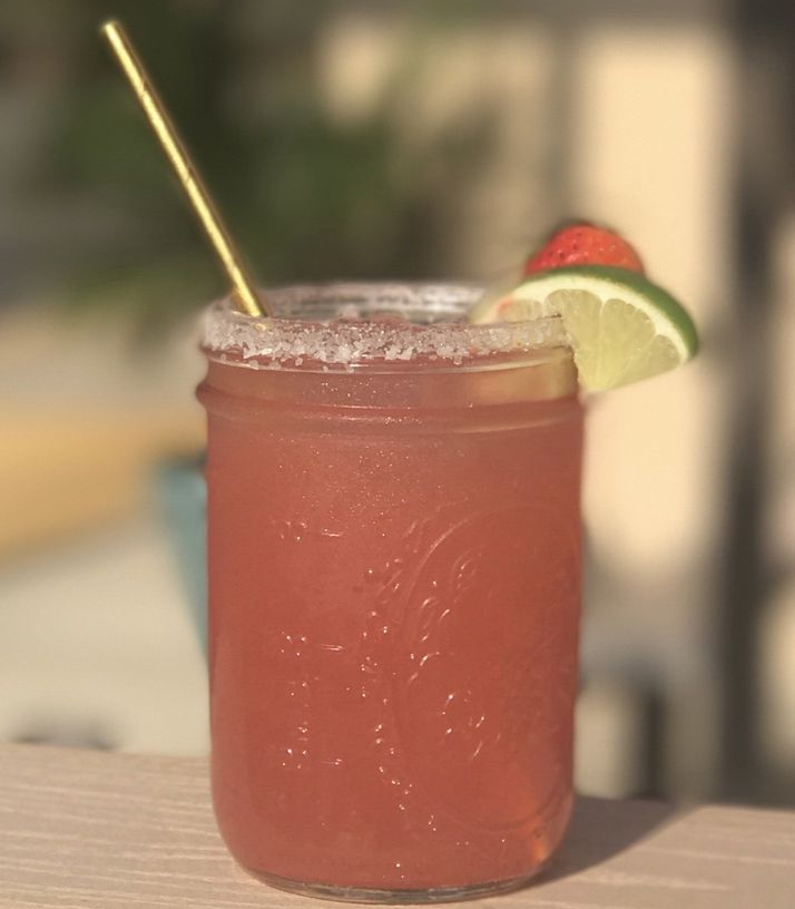 The Salty Papa Margarita in a mason jar with lime and watermelon